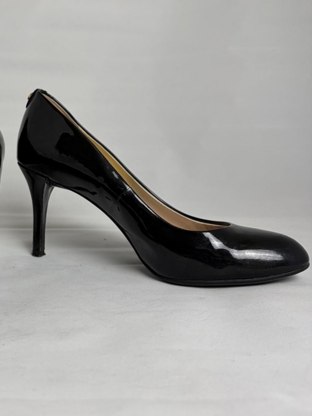 Shiny black patent Michael Kors pumps with luxe gold details